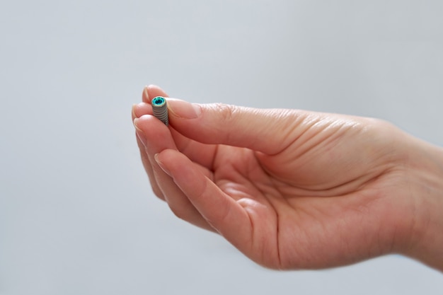 Closeup view of dentist holding dental implant in medical clinic