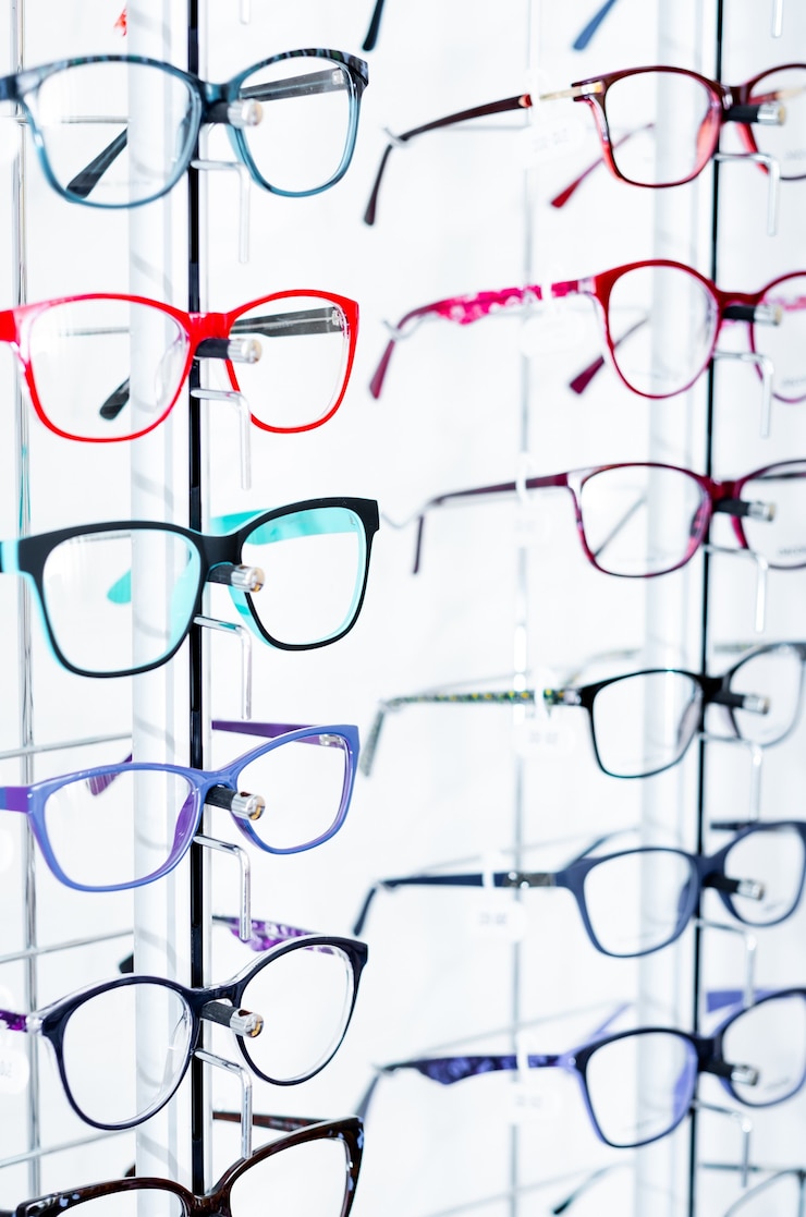 Photo closeup view of different colorful glasses for kinds on the showcase in the optical store
