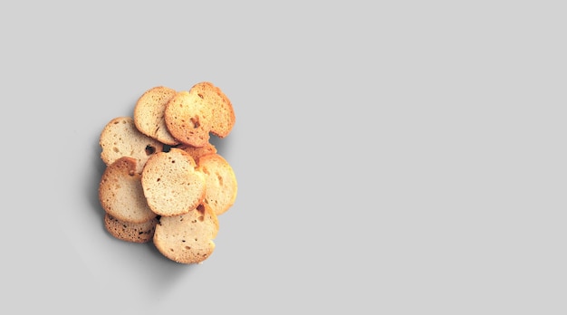 A closeup view of dry bread slices under the lights isolated on a grey background