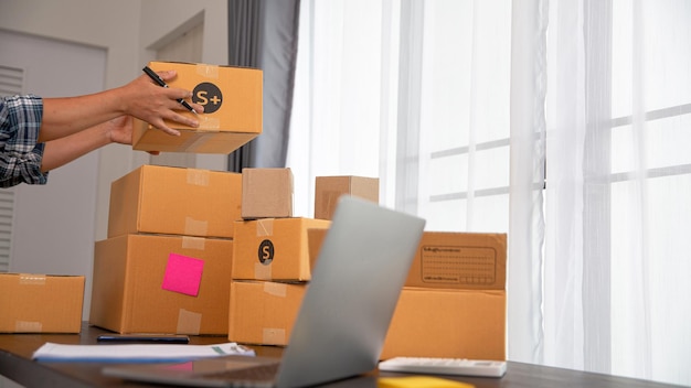 Closeup view of female packing package shipping box