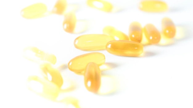 Closeup view of fish oil capsules on white background