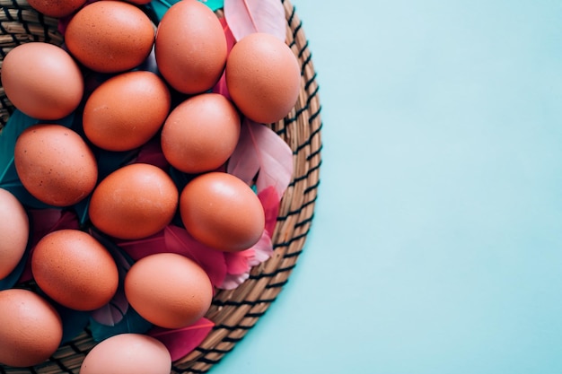 Closeup view from above lots of eggs on a blue pastel background with copy space. Happy Easter, food, spring, holiday concept