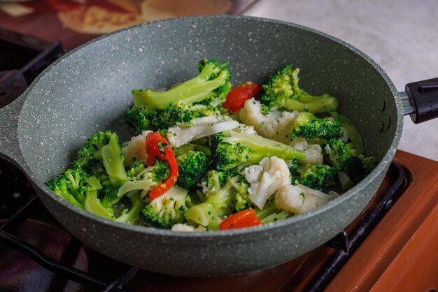 Closeup view of frying vegetables in pan without lid