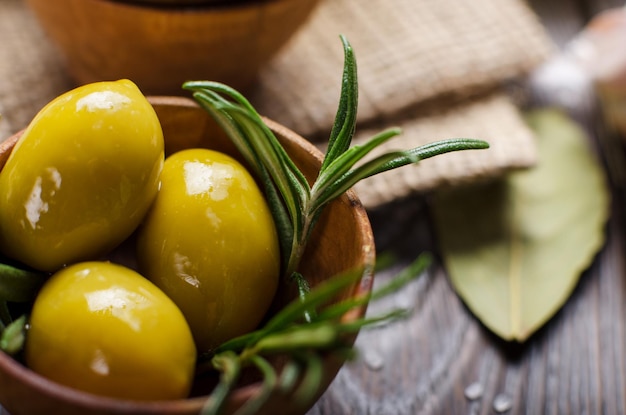 Closeup view of green olives oils and spices on kitchen table. Cooking concept