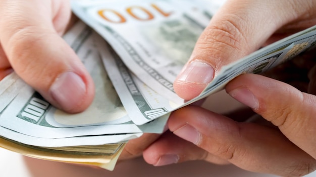 Closeup view of male businessman counting money in hands.