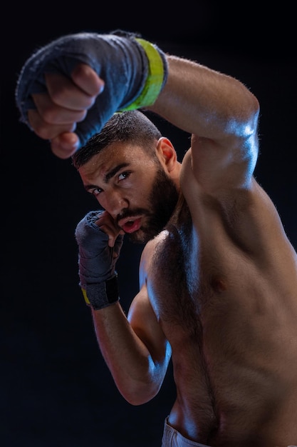 Closeup view on male hands of young athlete in gray bandages black background vertical