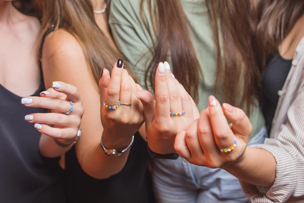 Closeup view of a mans hand showing a ring with an lgbt rainbow wristband