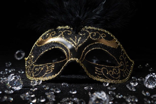 Photo closeup view of masquerade gold mask with gemstones on black background