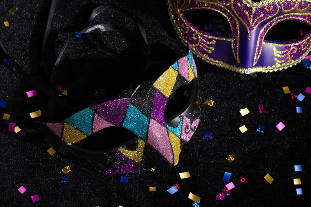 Closeup view of Masquerade mask with confetties on black background