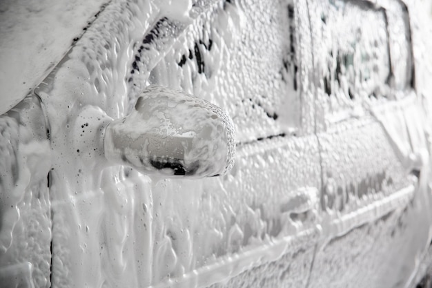 Closeup view of motor car with solid layer of soap sud during car wash