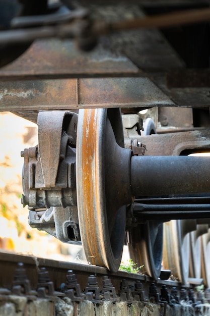 Foto vista ravvicinata di vecchie ruote arrugginite del telaio di un vagone ferroviario su rotaia