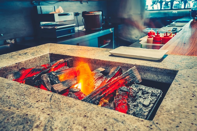 Closeup view of the open fireplace and the burning firewood for the cooking contemporary inside