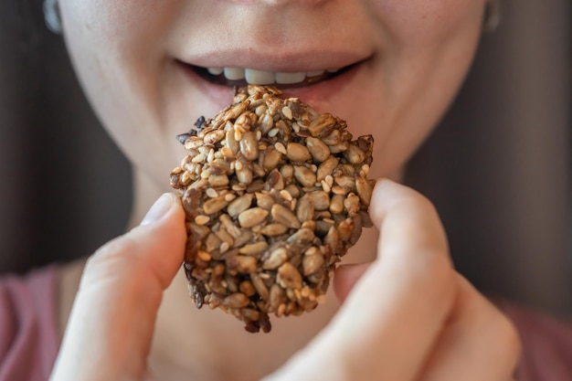 Closeup view of piece of cookies with banana and seeds in a womans hand