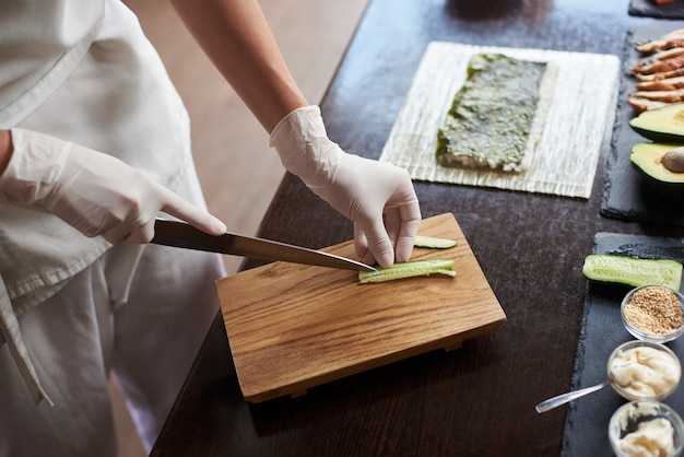 Closeup view of process of preparing delicious rolling sushi in restaurant