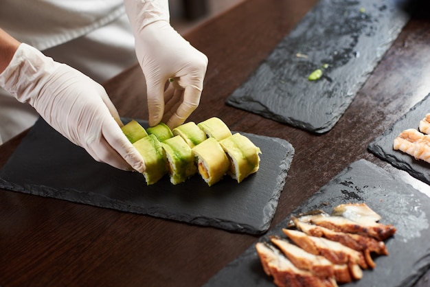 Closeup view of process of preparing rolling sushi