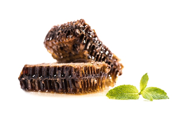 Closeup view of sweet healthy honeycombs and mint leaves isolated on white