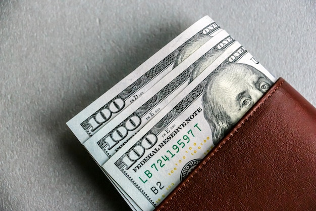 Closeup view of wallet with one hundred and fifty dollar banknotes.