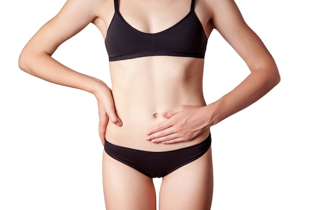 Closeup view of a young woman with stomach pain or digestion or period cycle on white background.