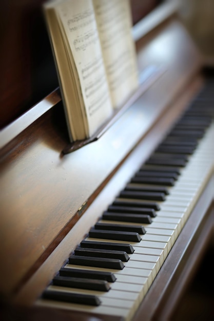 Closeup of a vintage piano and keyboard with a sheet music book An empty antique or wooden musical instrument for playing classical jazz or used for old traditional songwriting and rehearsals