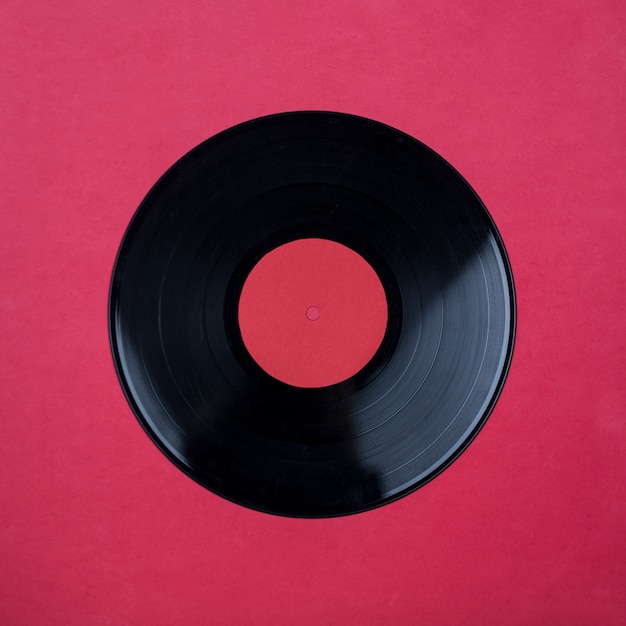 Photo closeup of vinyl long play record with label with copy space on red background