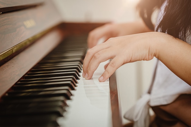 Closeup vrouw hand piano spelen thuis vintage colortone.