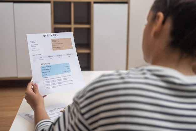 Closeup vrouw leest nutsrekeningen en gaat online betalen met behulp van moderne technologie