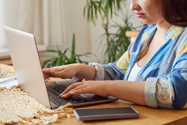 Closeup vrouw tekst typen op laptop toetsenbord remote werken thuis