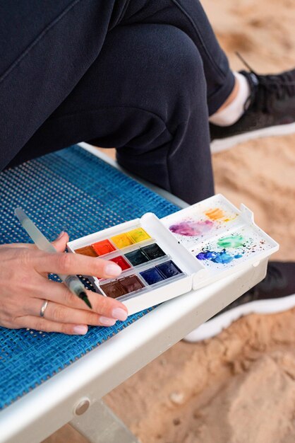 Photo closeup of watercolor palette young woman artist painting