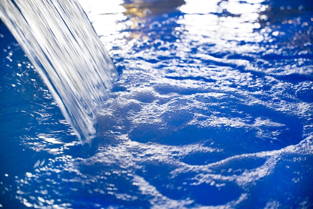 Foto primo piano di una cascata di acqua blu in una piscina coperta