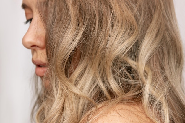 Closeup of the wavy blonde hair of a young blonde woman Result of coloring highlighting perming