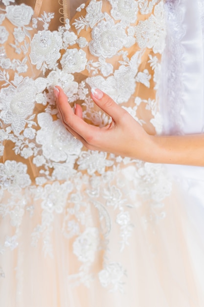 Closeup of wedding dress with lace and pattern.