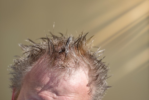 Primo piano della testa bagnata di un uomo soleggiato