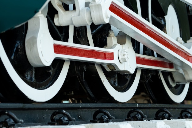 電車のクローズアップホイール。緑の赤と白の列車。アンティークヴィンテージ鉄道機関車。古い蒸気機関車。黒い機関車。古い輸送車両。