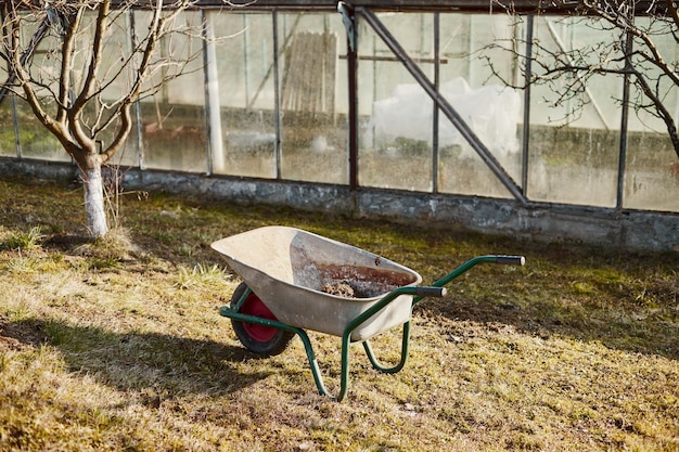 Primo piano di una carriola in giardino al tramonto