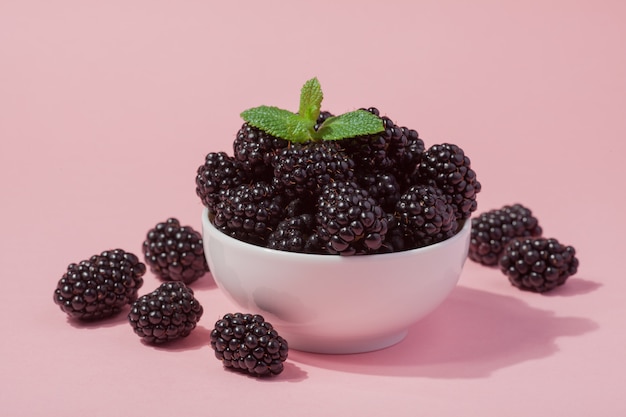 Closeup of a white bowl of fresh red raspberries.