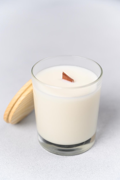 Closeup White Candle in Glass with Wooden Lid on Light Background Soft Blurry Focus Place Label