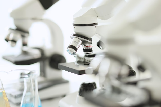 Closeup of white microscopes standing in row in laboratory equipment for medical research tests