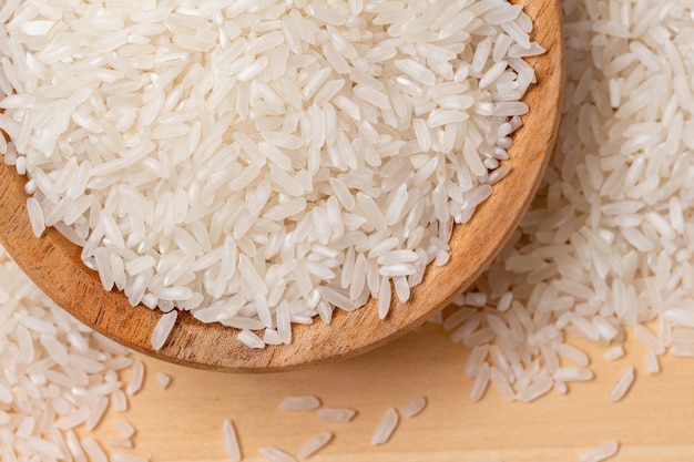 крупным планом белый рис в деревянной миске на фоне дерева