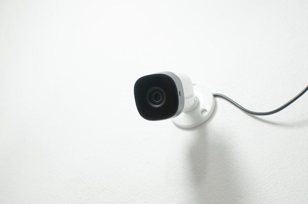 Closeup of a white security camera in an environment conveying the feeling of protection and constant surveillance