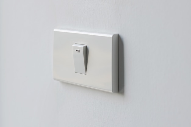 Photo closeup a white switch for on and off wall lighting for office and residential.