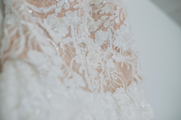 Closeup of the white wedding dress hanging on the wall