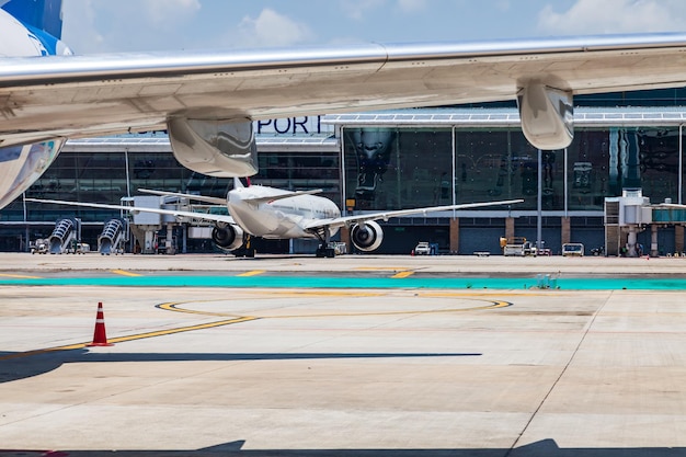 Photo closeup on the wing of a passenger aircraft with a turbine at the airport in thailand travel and cargo transportation