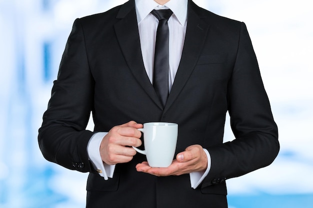 Primo piano con la mano dell'uomo d'affari che tiene il caffè