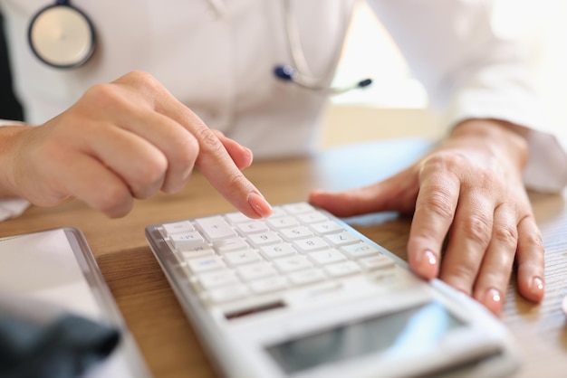 Closeup of woman accounting on calculator in office at workplace business accounting savings