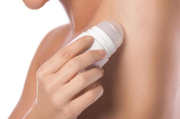 Photo closeup of woman applying deodarant on her armpit