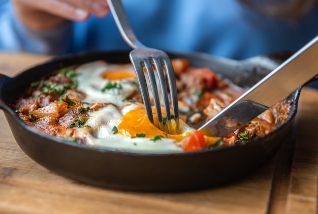 Closeup a woman in a cafe dines on traditional shakshuka