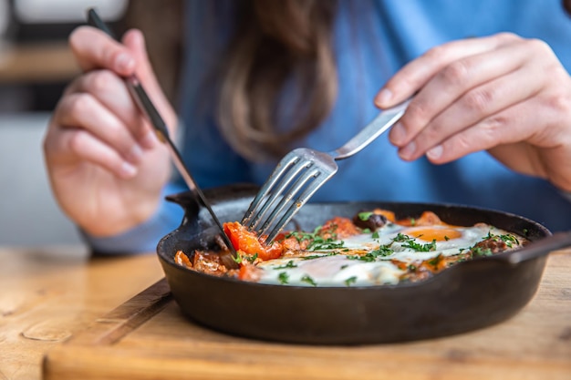 Closeup a woman in a cafe dines on traditional shakshuka