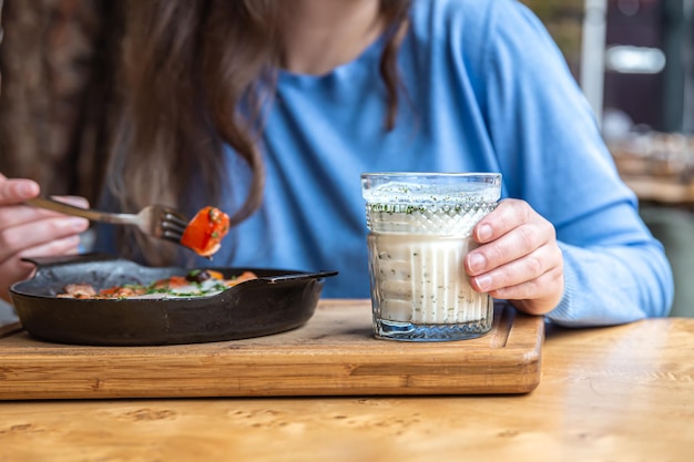 伝統的なシャクシューカで食事をするカフェの女性をクローズアップ