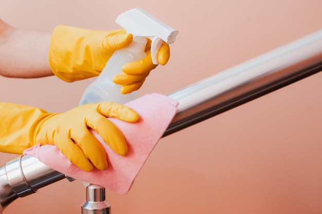 Closeup of a woman cleaning the stair railing Spring cleaning disinfection in coronavirus service