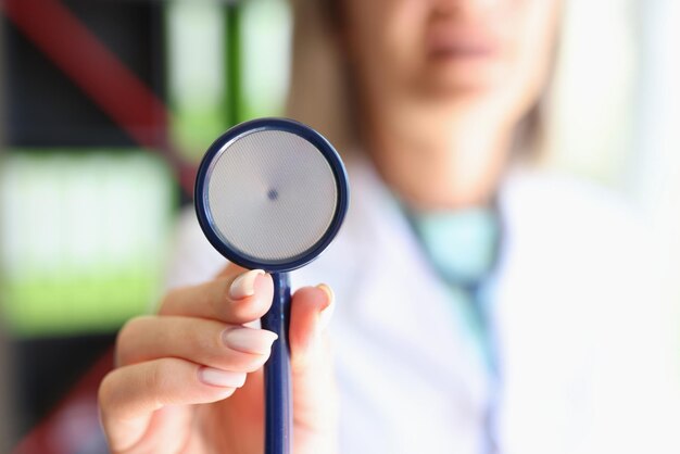Closeup of woman doctor posing in clinic office and showing stethoscope medicine treatment and